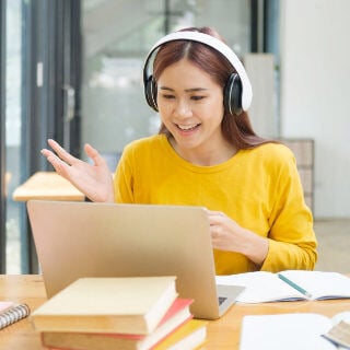 Student looking at her laptop while wearing headphones