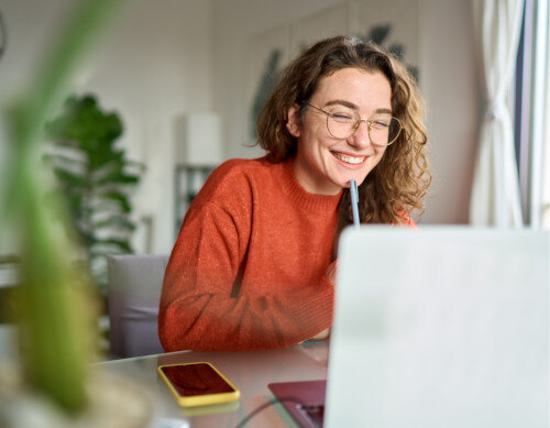 Person smiling and working at their computer